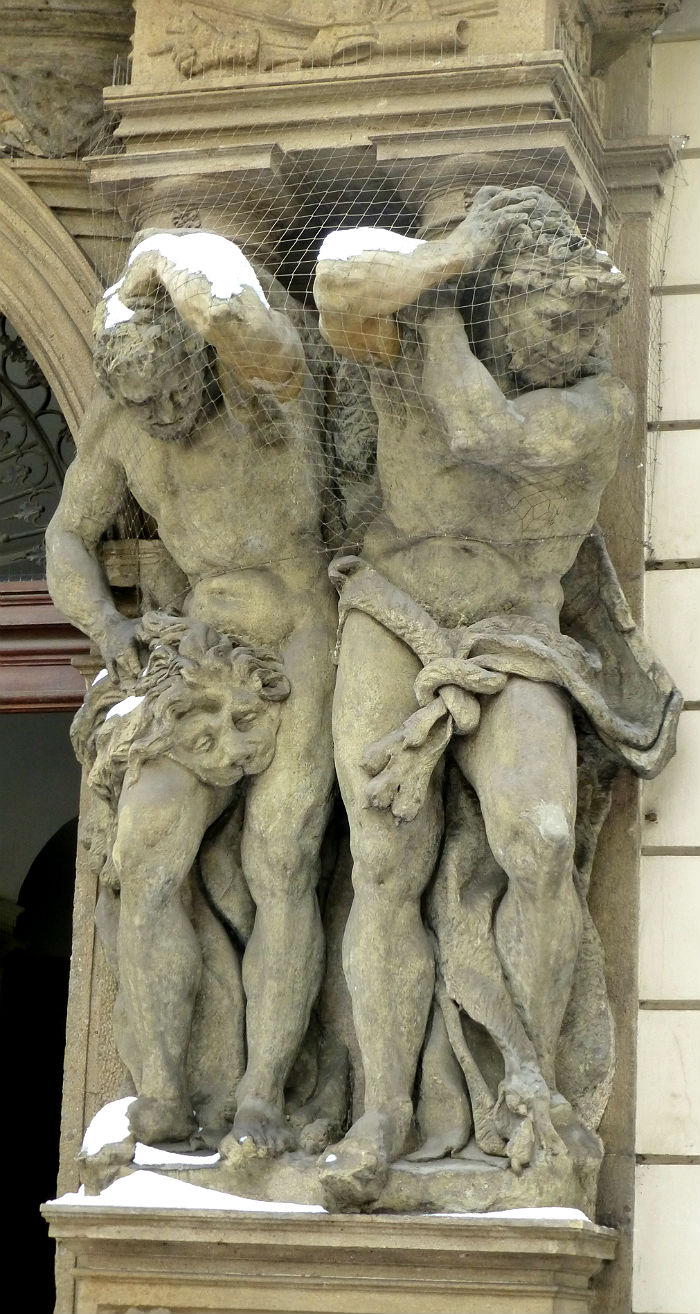 Two statues holding a balcony